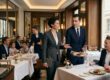 Restaurantleitung im Anzug begrüßt Gäste an einem eingedeckten Tisch im gehobenen Restaurant